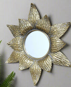 Decorative gold sun-shaped mirror on a brick wall