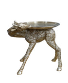 Gold animal-shaped side table against a stone wall background