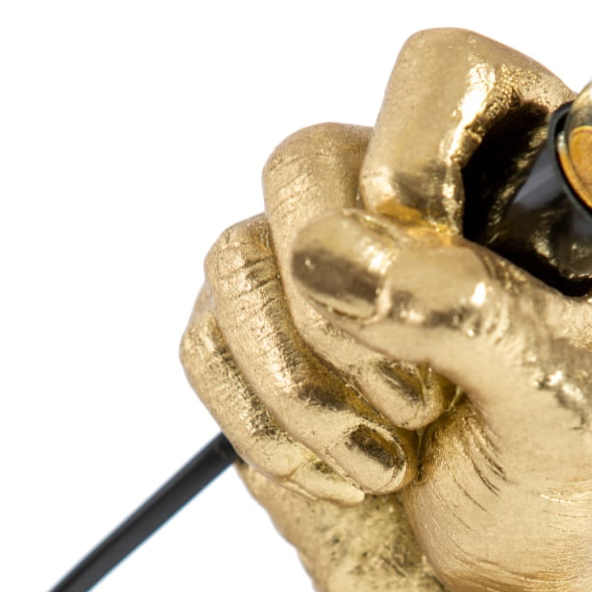 Gold fist holding a black cord against a white background