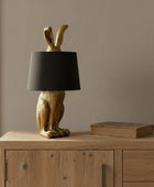 Decorative lamp with rabbit design and black shade on a white background
