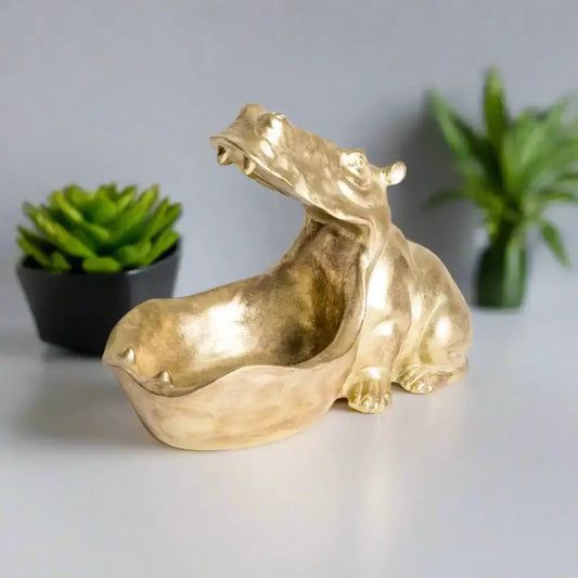 Gold-colored sculpture of a stylized animal on a white background