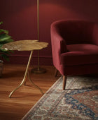 Decorative side table with leaf pattern against a teal wall