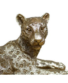 Bronze leopard statue on a wooden surface with a blurred background