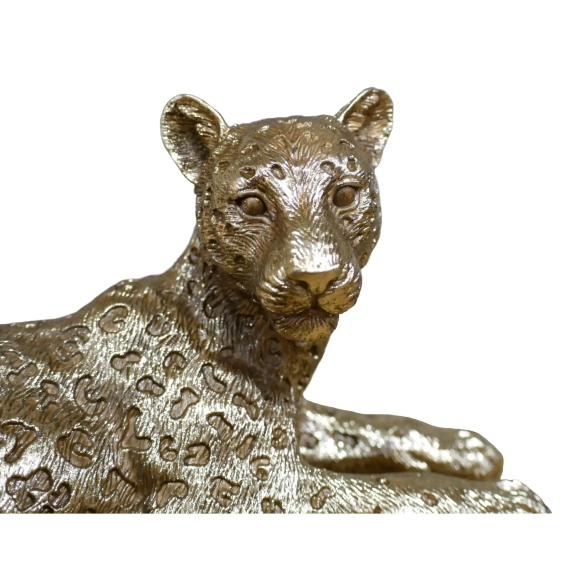 Bronze leopard statue on a wooden surface with a blurred background