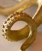 Gold decorative item with textured design on a light background