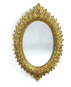 Decorative gold mirror with intricate design on a white background