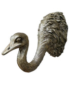 Bronze ostrich head sculpture on a brick wall