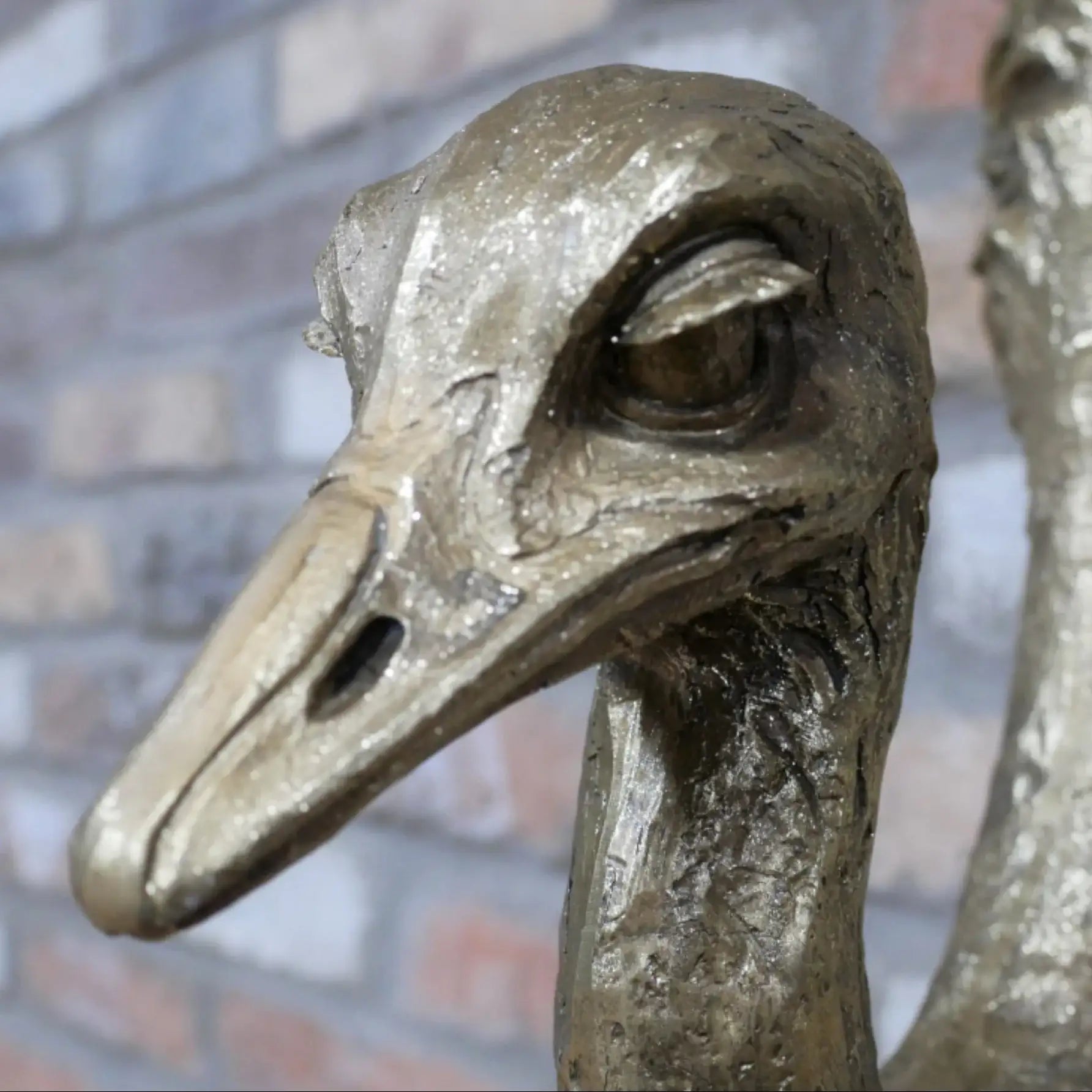 Bronze statue of an ostrich head with a blurred background