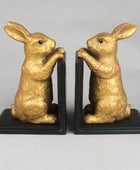 Gold rabbit bookends on black bases against a gray background