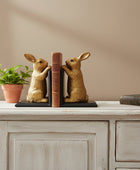 Gold rabbit-shaped bookends on a gray background