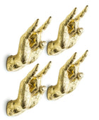 Four gold hand-shaped wall hooks on a white background