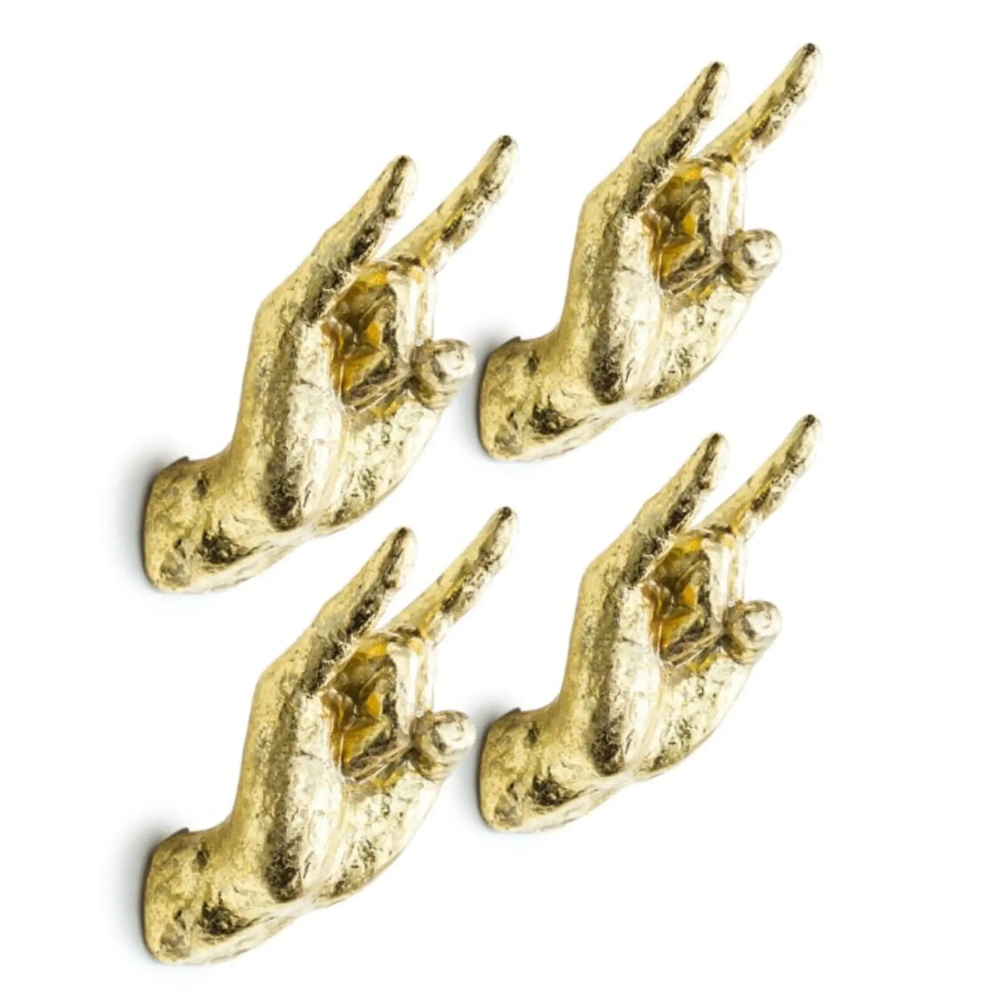 Four gold hand-shaped wall hooks on a white background