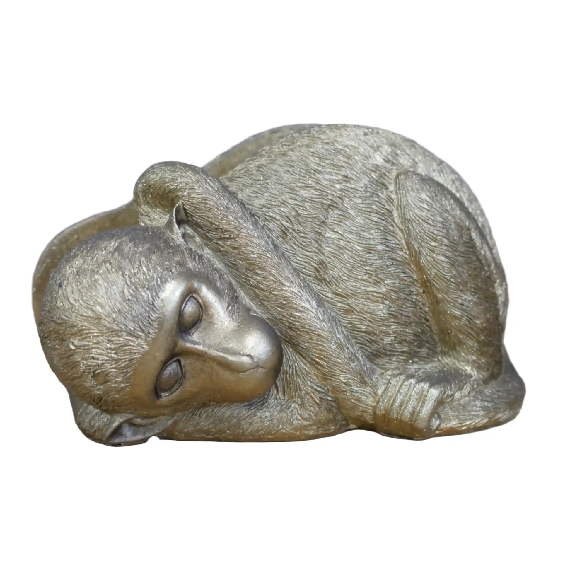 Bronze sculpture of a cat curled up on a wooden surface with a blurred background