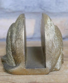 Decorative metal bookend with a textured surface on a wooden surface.