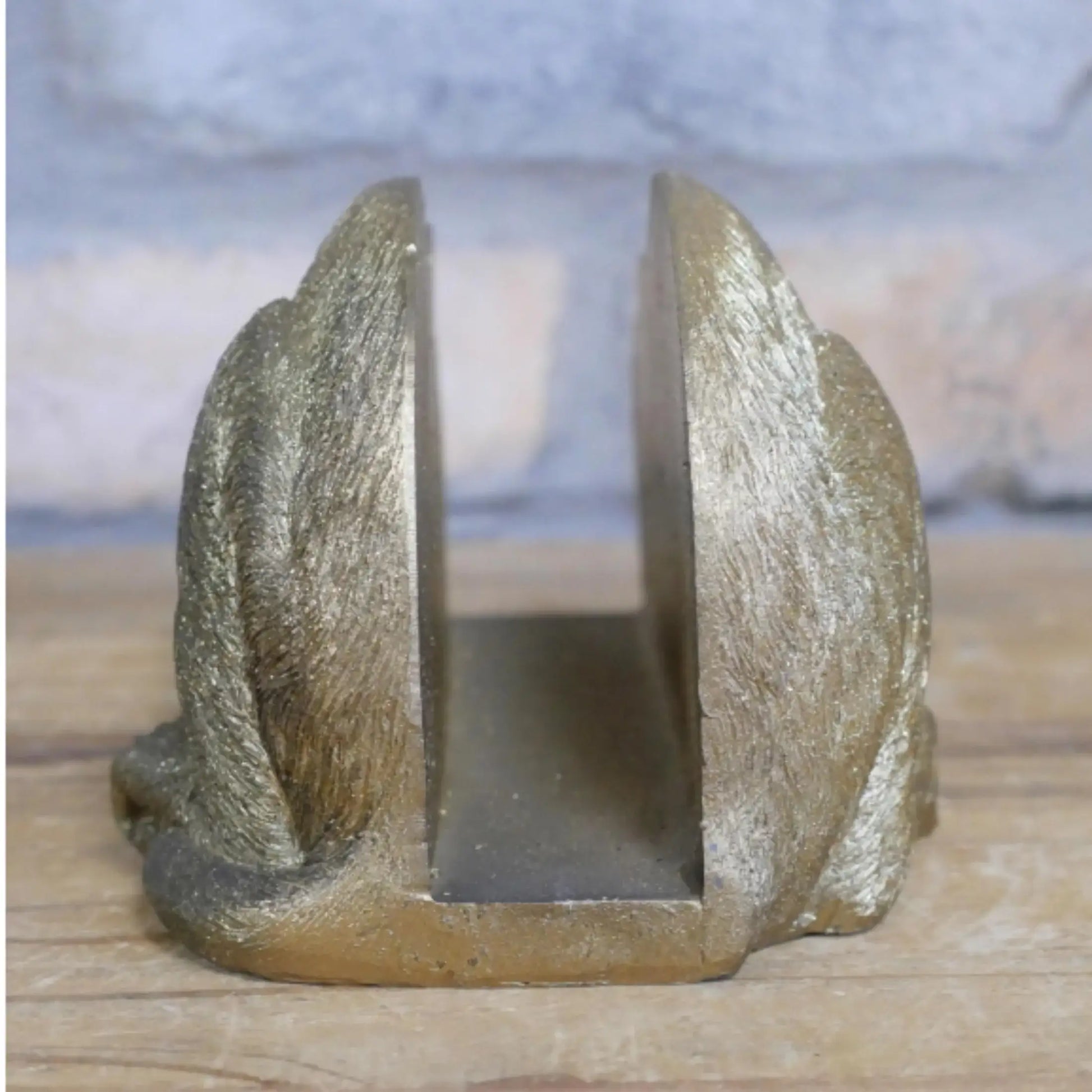 Decorative metal bookend with a textured surface on a wooden surface.