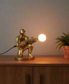 Gold-colored figurine of a soldier with a weapon on a white background