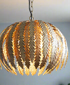 Decorative pendant light with leaf-like design on a blurred background