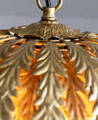 Close-up of a gold decorative lamp with intricate leaf patterns.