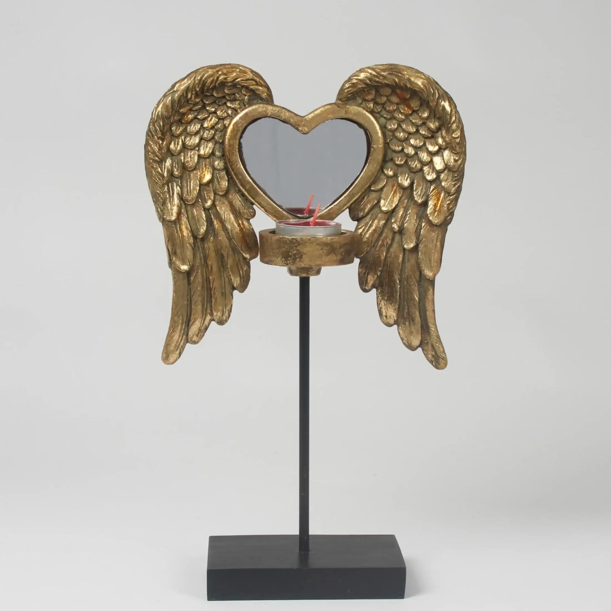 Decorative candle holder with gold angel wings and a heart-shaped design on a white background
