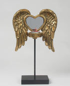 Decorative candle holder with gold angel wings and a heart-shaped design on a white background