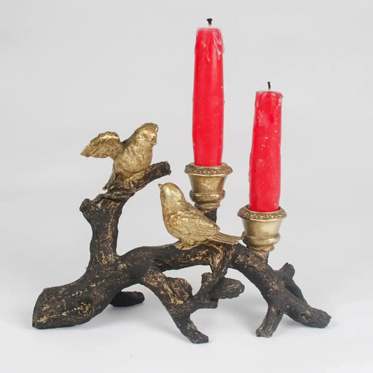 Decorative candle holder with birds and red candles on a white background