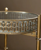 Decorative metal stand with intricate patterns and coral-like material on a blurred background