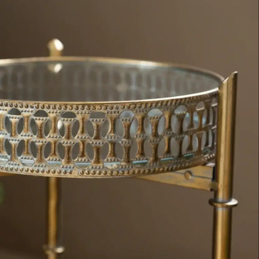 Decorative metal stand with intricate patterns and coral-like material on a blurred background