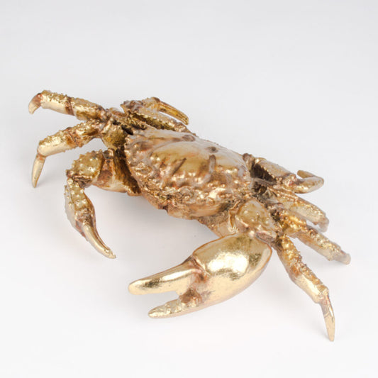 Gold crab figurine on a white background