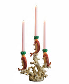 Candle holder with fish design holding three candles on a white background