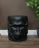 Black gorilla head stool on a wooden floor with a neutral wall background