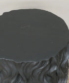 Black textured round table on a plain background