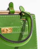 Green handbag with gold clasp on a white background