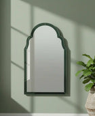 Wall mirror with green frame on a white background