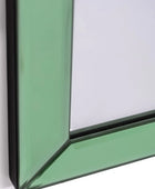 Close-up of a green glass panel with a black frame on a white background