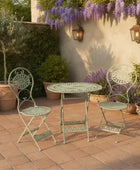 Outdoor patio set with two chairs and a table on a brick patio.
