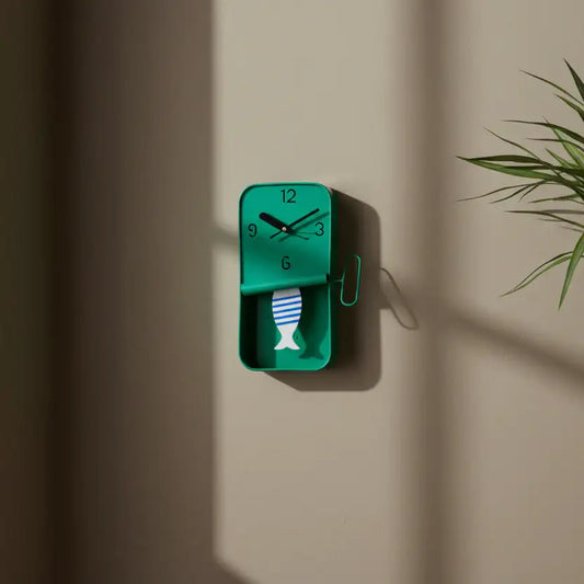 Green wall clock with fish design on a beige wall