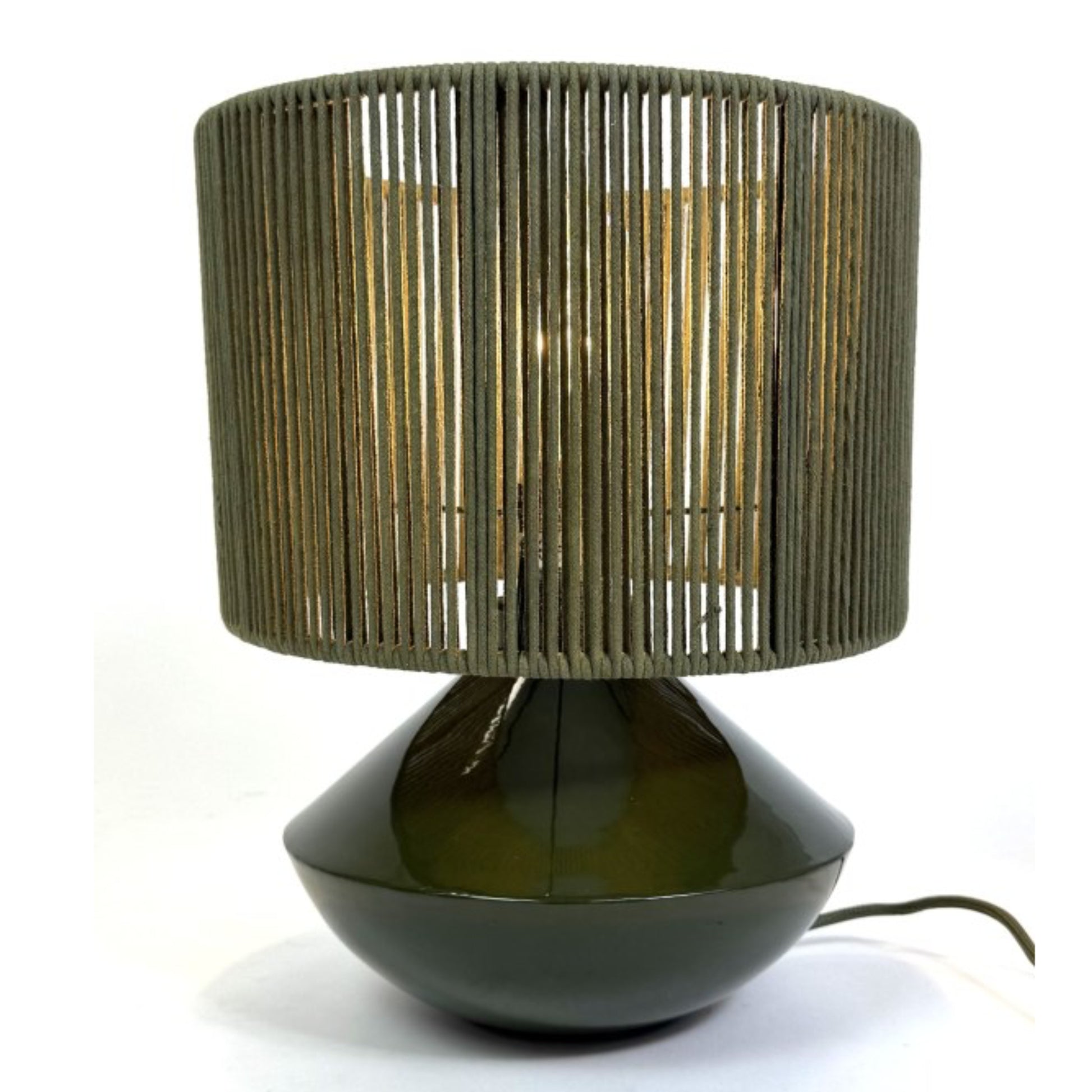 Table lamp with a green woven shade and black base on a white background