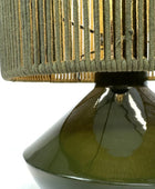 Close-up of a green lamp with a textured shade on a white background