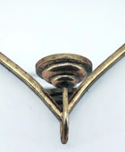 Close-up of a brass bracket on a white background