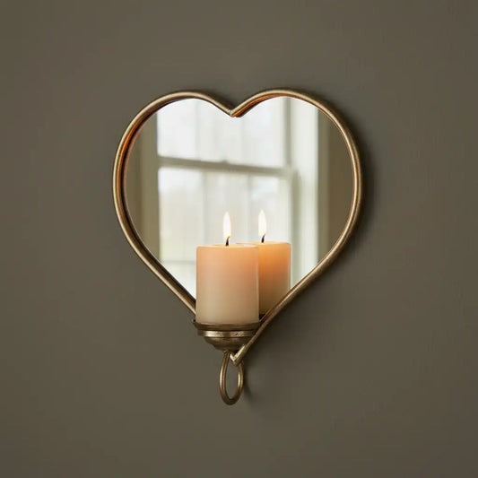 Heart-shaped mirror with candle holder on a brown wall