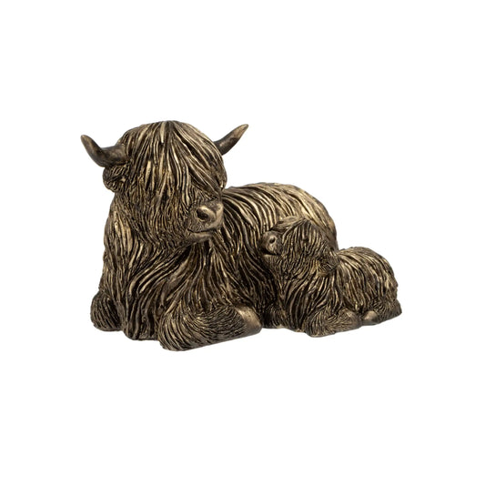 Bronze sculpture of a mother cow and calf on a white background