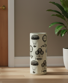 Umbrella stand with hot air balloon design on a wooden floor next to a plant