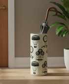 Umbrella in a decorative holder with hot air balloon pattern on a wooden floor.