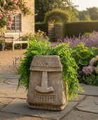 Decorative stone totem with greenery against a brick wall