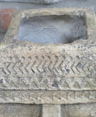 Decorative stone box with geometric patterns on a textured background