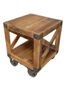 Wooden side table with metal accents on a carpeted floor against a gray wall.