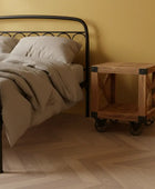Bedroom with a metal bed frame, wooden nightstand, and beige walls.