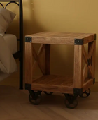 Wooden side table with metal accents next to a bed in a bedroom setting.