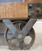 Wooden table with metal wheels on a carpeted floor