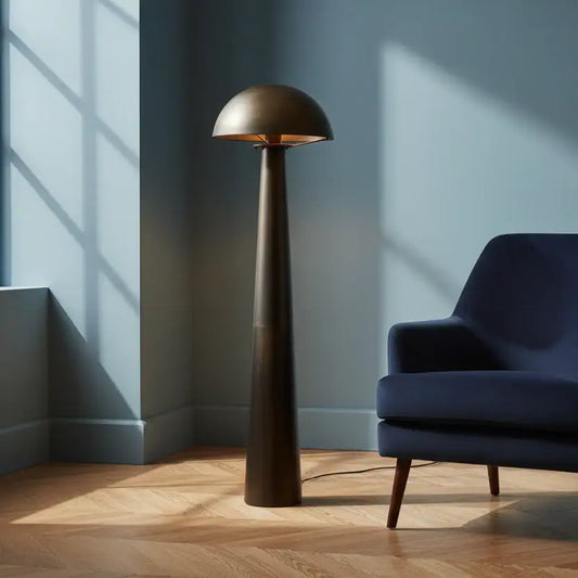 Modern floor lamp next to a blue armchair in a room with sunlight streaming through a window.